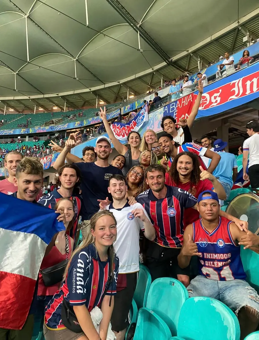 A big group of travelers cheering at a football match in Salvador