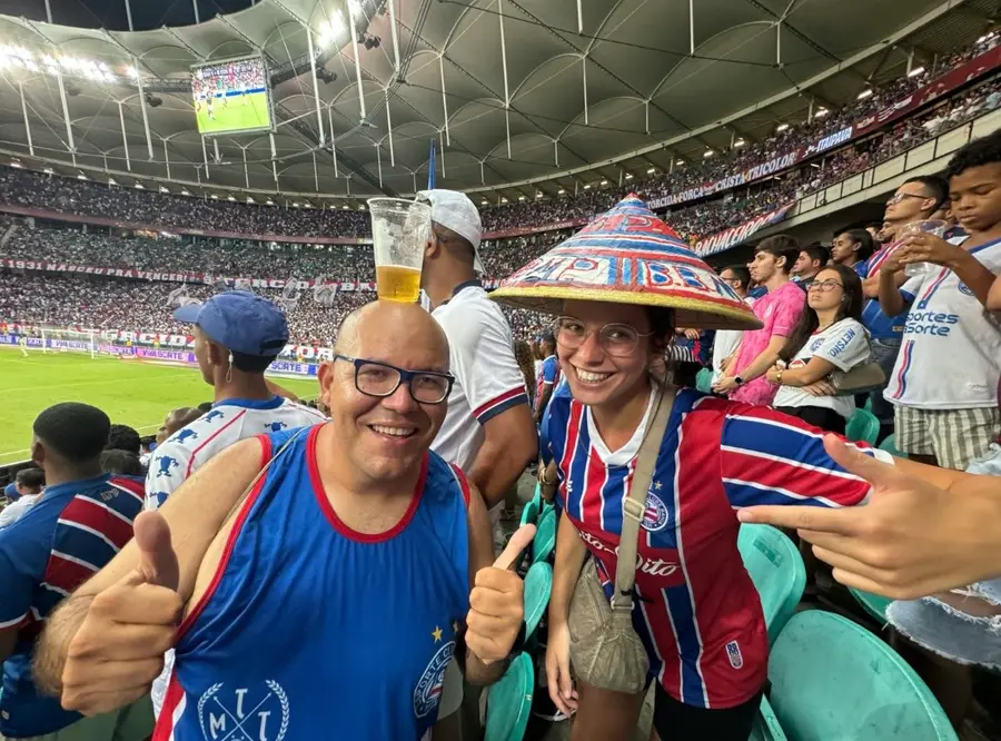 Travelers in team shirts at a football match with our guide